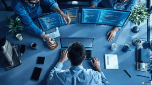 a group of people sitting around a table with computers